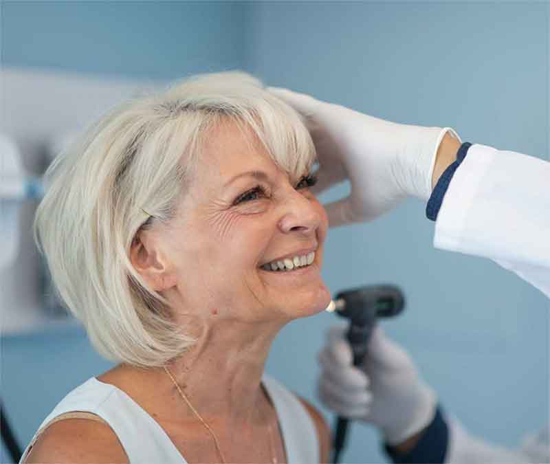 Woman having her ears examined by a hearing expert.